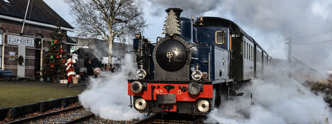 Een stoomtrein staat op het punt om te vertrekken, terwijl een kerstman de trein uitzwaait op het perron.