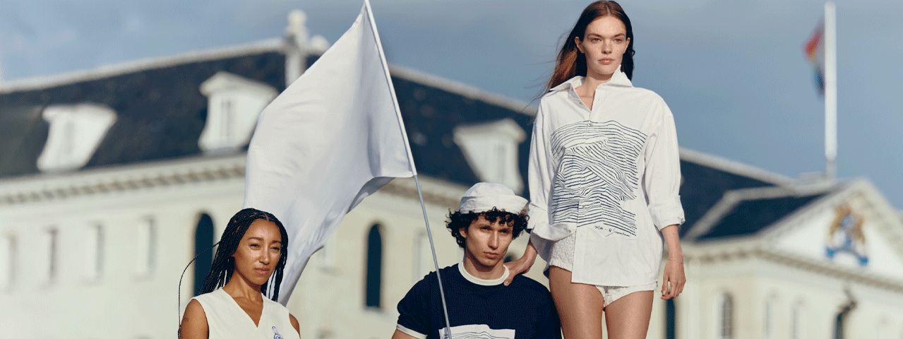 Drie modellen in nautisch geïnspireerde kleding staan voor het Scheepvaartmuseum. Het middelste model draagt een witte vlag. Met de VIP-KAART 2 gratis tickets voor de tentoonstelling Oceanista.