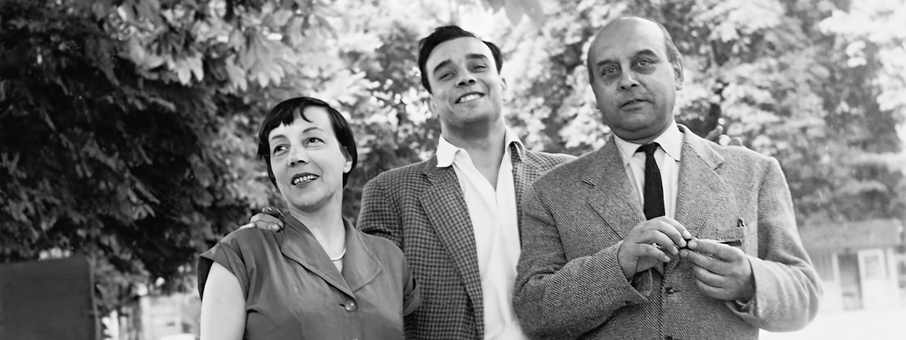 Een zwart-wit foto van een lachende jonge man die aan beide zijden geflankeerd wordt door zijn vader en moeder. Bezoek de tentoonstelling Yves Klein gratis met de VIP-KAART!