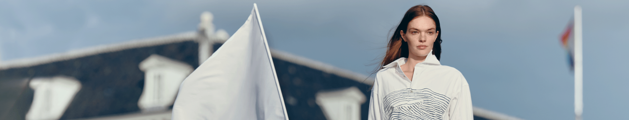Drie modellen in nautisch geïnspireerde kleding staan voor het Scheepvaartmuseum. Het middelste model draagt een witte vlag. Met de VIP-KAART 2 gratis tickets voor de tentoonstelling Oceanista.