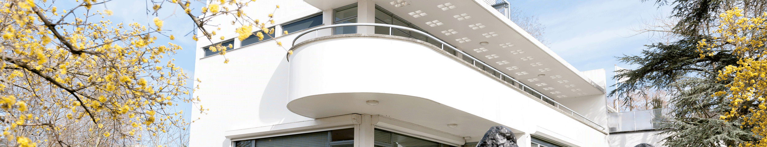 Het modernistische, witte gebouw van het Chabot Museum in de stijl van het nieuwe bouwen. Voor het gebouw ligt een grote sculptuur van een liggende hand. Ontvang gratis entree bij het Chabot Museum met de VriendenLoterij VIP-KAART!