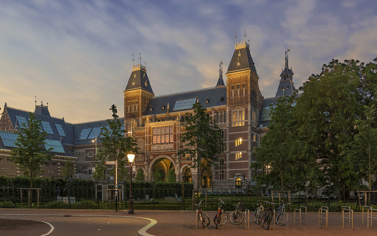 Voorgevel van het Rijksmuseum in de avondschemering.
