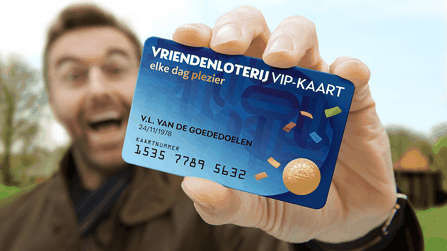 Een persoon houdt een VriendenLoterij VIP-kaart omhoog voor de camera.