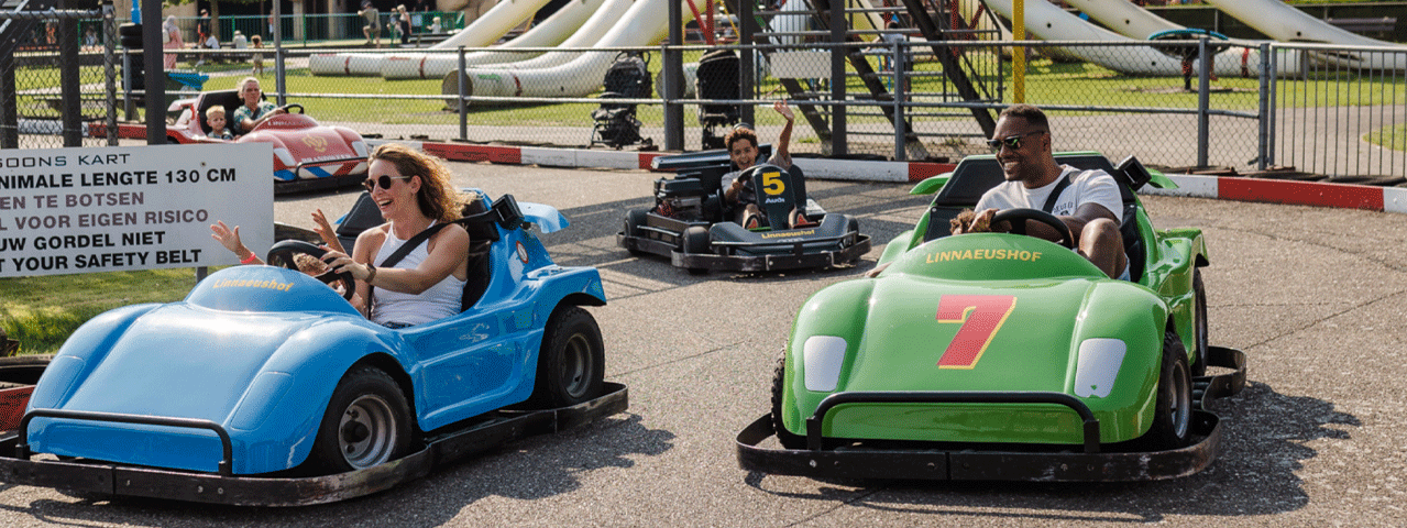 Twee gezinnen racen samen op de kartbaan van Linnaeushof op een zonnige dag. Ontvang korting bij Linnaeushof met de VIP-KAART
