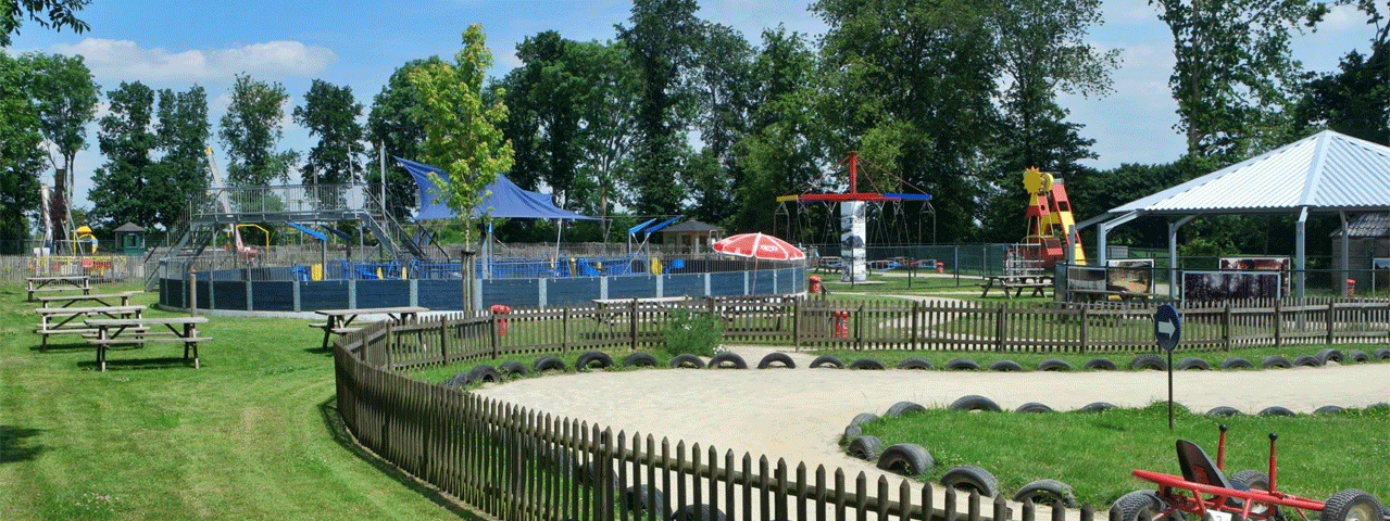 Een speelpark met diverse buiten speeltoestellen op een grasveld. Ontvang korting bij Sybrandy's Speelpark