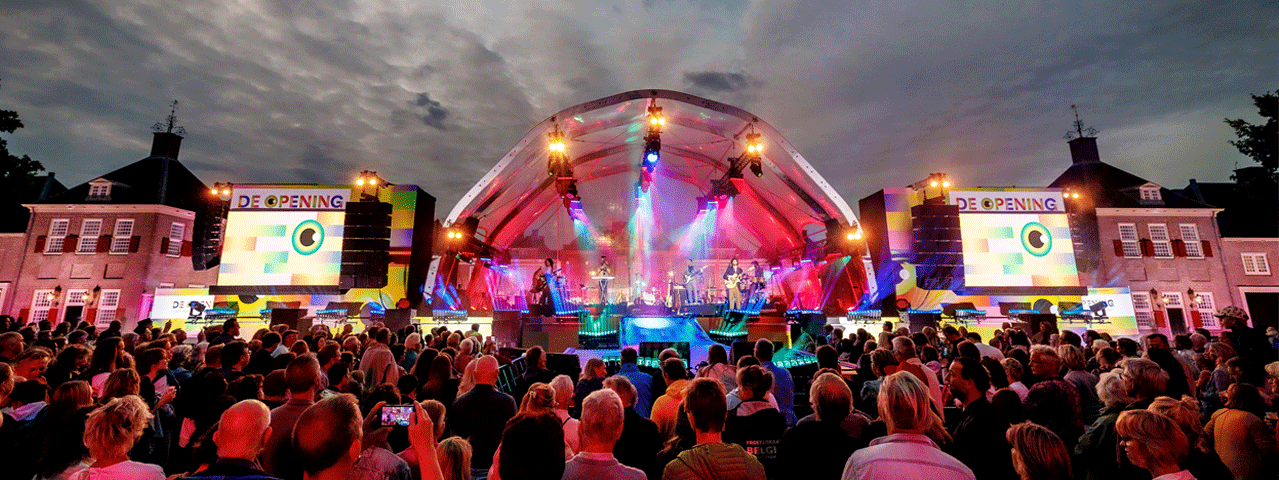 Publiek kijkt 's avonds een optreden in een tent