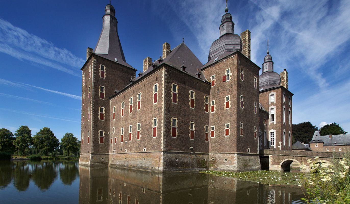 Zicht op het imposante kasteel Hoensbroek, met op de voorgrond de slotgracht. Met de VIP-KAART bezoekt u dit mooie kasteel helemaal gratis.