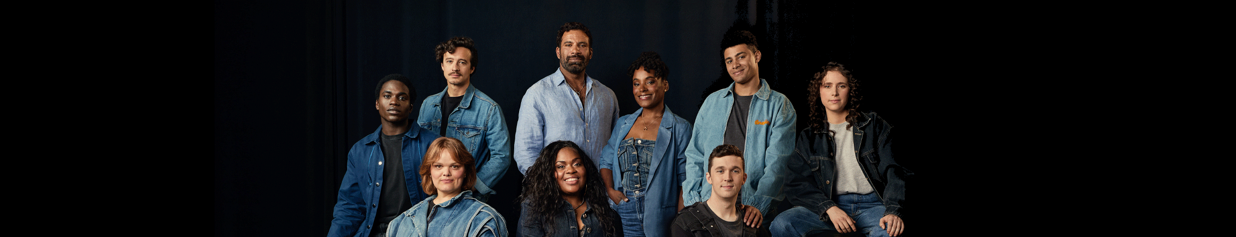 Een groep mensen in denim kleding poseert voor een zwarte achtergrond. Ontdek The Little Big Things met korting in Carré.