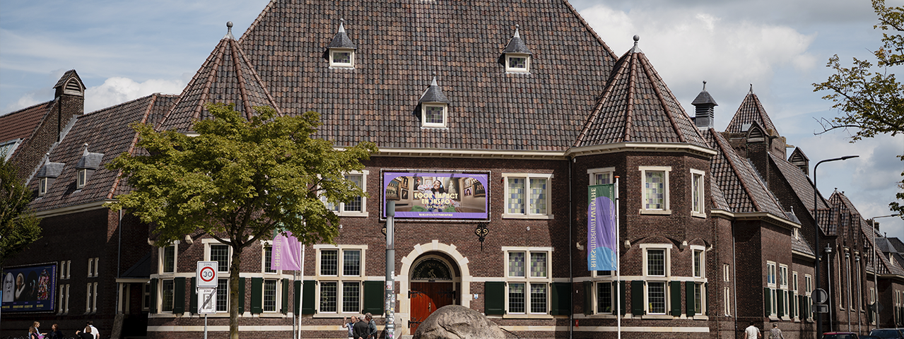 Rijksmuseum Twenthe in Enschede, historisch gebouw met bakstenen gevel en banners voor kunsttentoonstelling.