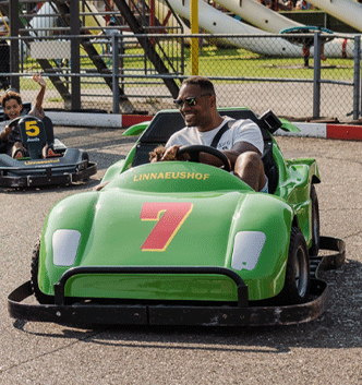 Twee gezinnen racen samen op de kartbaan van Linnaeushof op een zonnige dag. Ontvang korting bij Linnaeushof met de VIP-KAART