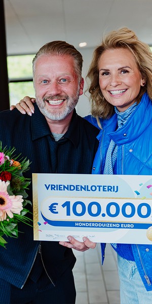 Meneer poseert met een cheque van €100.000 van de VriendenLoterij.