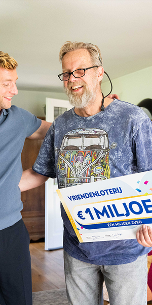 Een man reageert blij op een cheque van €1 miljoen van de VriendenLoterij.