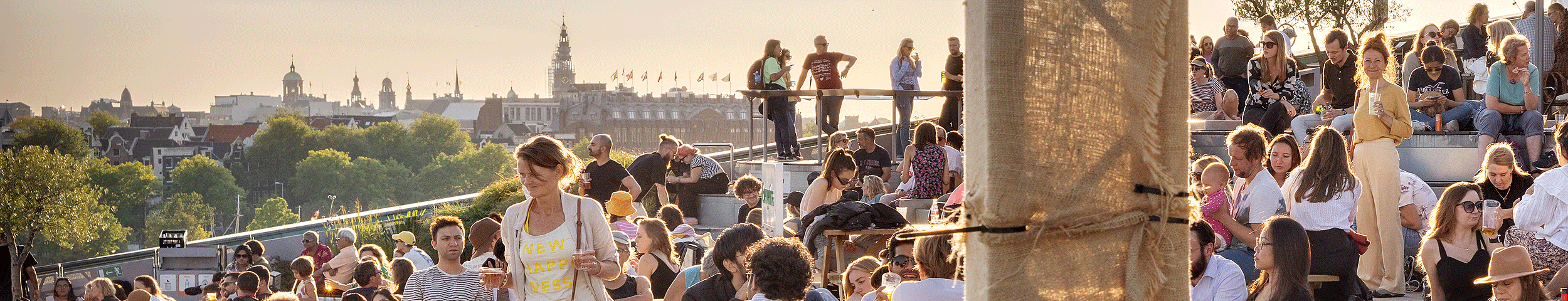Het dakterras van NEMO vol publiek dat geniet van de zomerse sfeer. Ontdek meer leuke dagjes uit in de zomer met de VIP-KAART!
