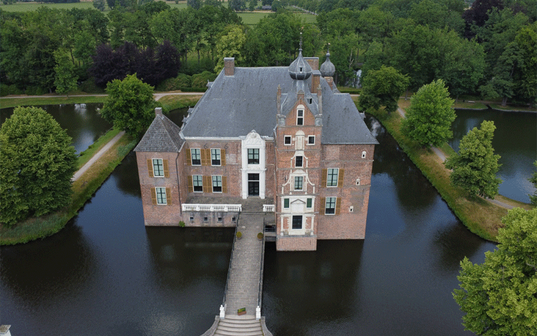 Luchtfoto van een bakstenen kasteel omgeven door een slotgracht. Bezoek kasteel Cannenburgh gratis met de VIP-KAART!