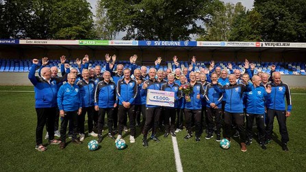 Leden van SV Deurne vieren samen op het voetbalveld een VriendenLoterij-cheque van € 5.000,-.