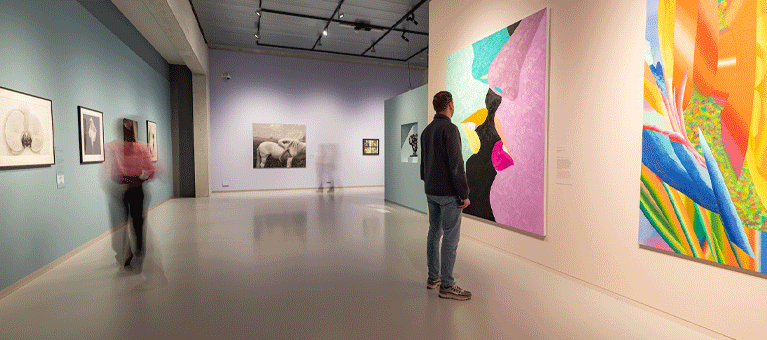 Bezoekers kijken naar kleurrijke schilderijen in het moderne museumgebouw van het Limburgs Museum. Met de VIP-KAART ontvang je gratis entree in dit Limburgse museum.