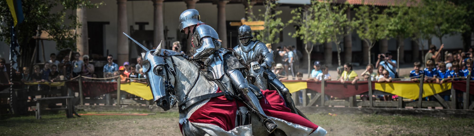 Een spannend riddergevecht te paard in openluchtmuseum Archeon, terwijl van een afstandje de bezoekers toekijken. Gratis te bezoeken met de VIP-KAART!