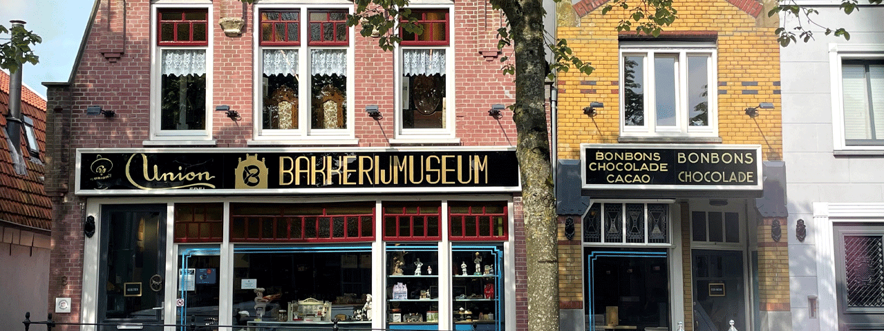 De historische gevels van het Bakkerijmuseum, met een vitrine vol bijzondere en lekkere producten. Deelnemers bezoeken dit museum gratis met de VIP-KAART.